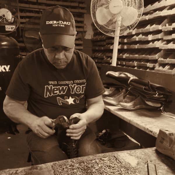 An artisan stitching a boot at the bench